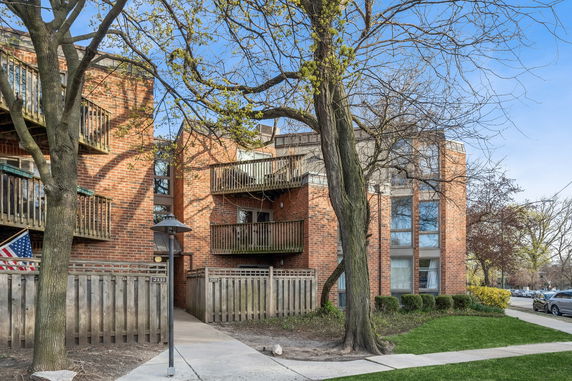 Front view of a multi-story brick building with balconies.