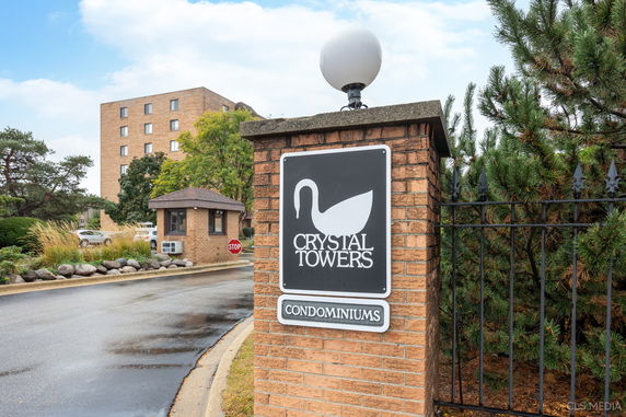 Front view of a condominium building with a sign reading 'Crystal Towers Condominiums'.