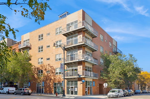 Front view of a multi-story apartment building with balconies.