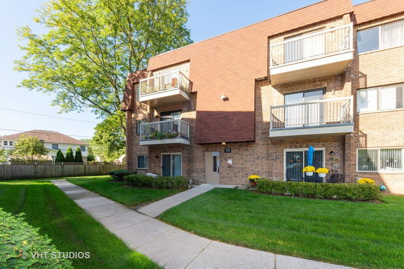 Front view of a three-story apartment building with balconies.