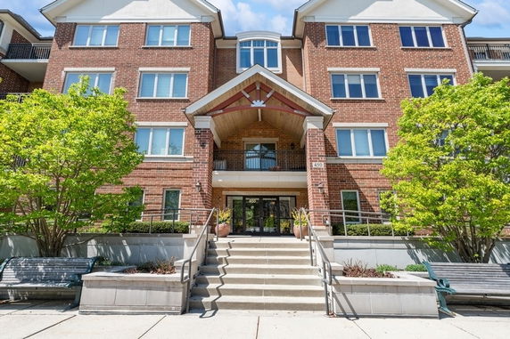 Front view of a multi-story brick building with steps leading to the entrance.