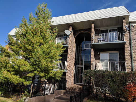 Front view of a multi-story residential building with balconies.
