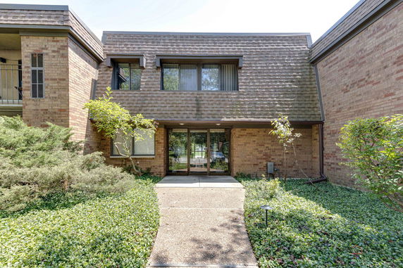 Front view of a two-story brick building with shingle-style roof.