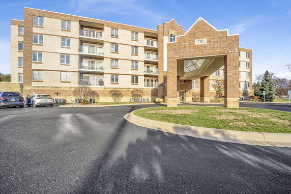 Front view of a multi-story building with a covered driveway entrance.