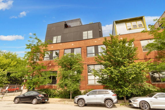 Front view of a multi-story brick building with modern upper addition.