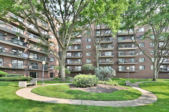 Front view of a multi-story apartment building with balconies.