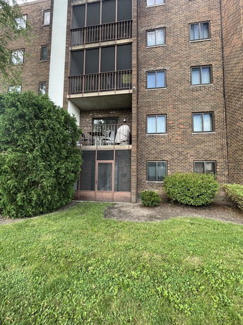 Front view of a multi-story brick apartment building with balconies.