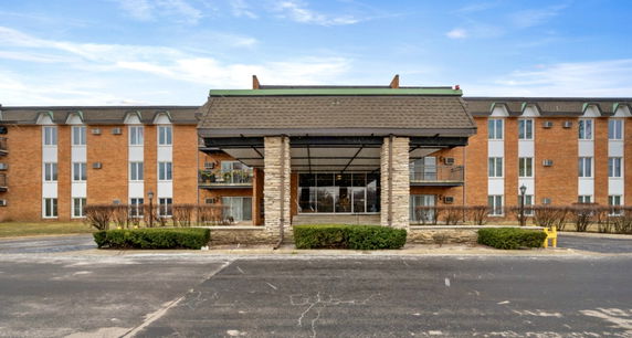 Front view of a multi-story brick building with a covered entrance.
