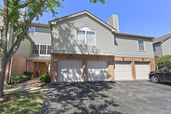 Front view of a two-story house with garage and brick facade.