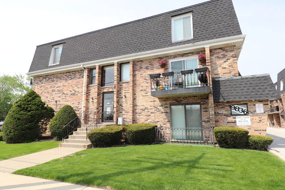 Front view of a multi-story brick building with balconies.