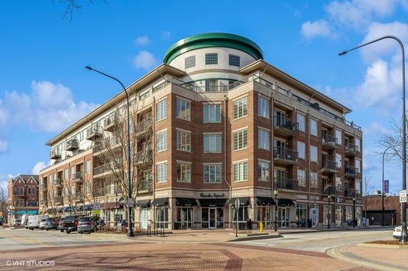 Front view of a multi-story building with brick facade and balconies.