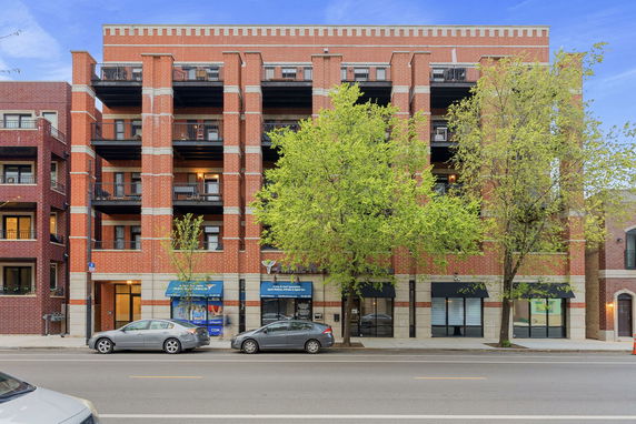 Front view of a multi-story brick building with balconies.