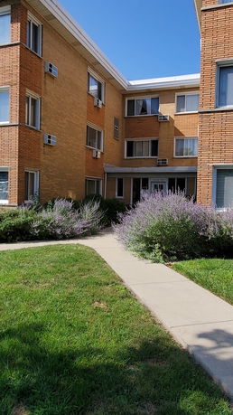 Front view of a multi-story brick apartment building.