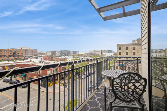 Balcony view overlooking a cityscape with buildings and streets.