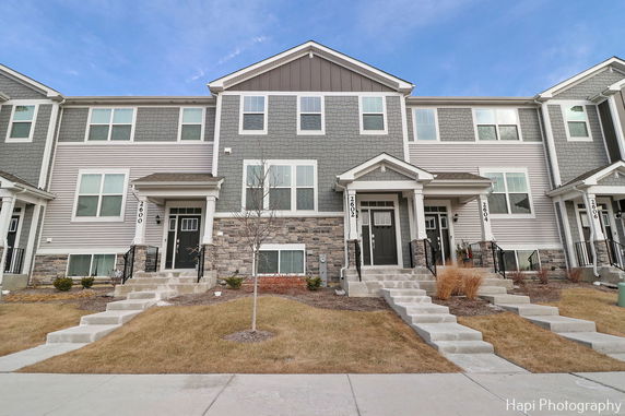 Front view of a multi-story townhouse building with multiple entrances.