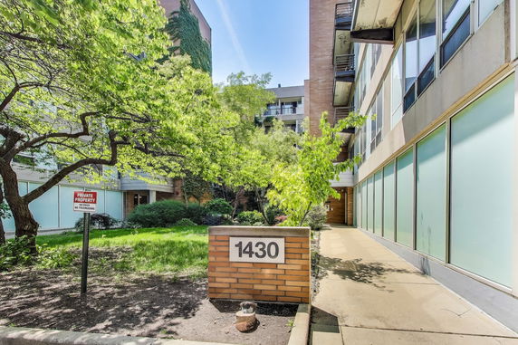 Front view of a mid-rise building with large windows and a sign reading 1430.