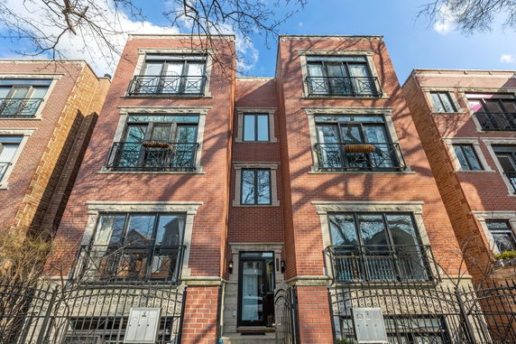 Front view of a multi-story brick building with balconies.