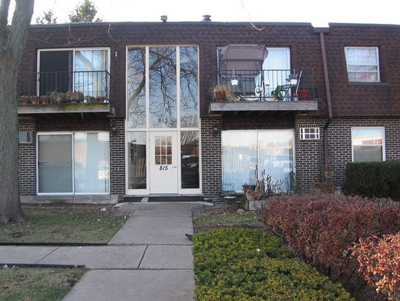 Front view of a two-story building with balconies and a central entrance.
