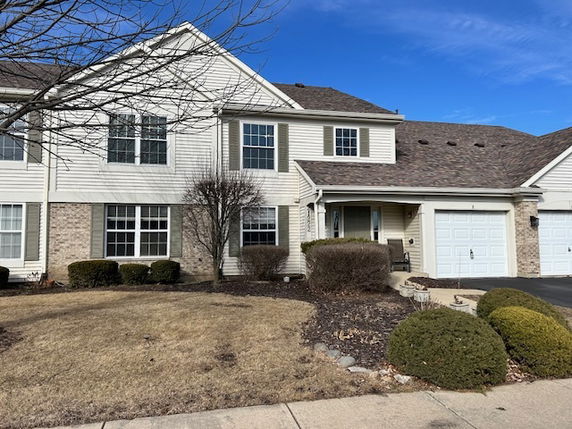 Front view of a two-story house with an attached garage.