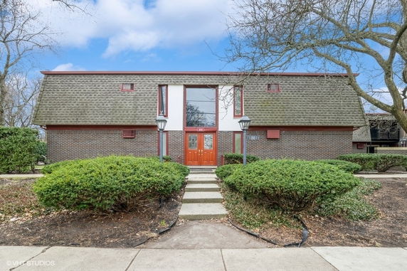 Front view of a two-story brick building with a distinctive roof.