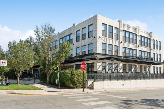 Corner view of a multi-story commercial building with large windows and a modern design.
