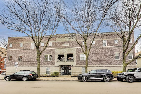 Front view of a multi-story brick building with multiple windows and a central entrance.