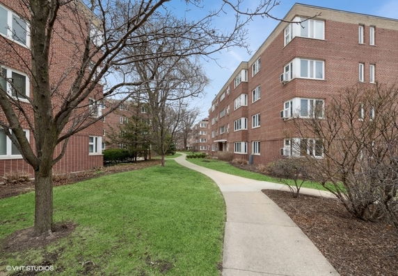 Front view of a brick residential apartment building with large windows.
