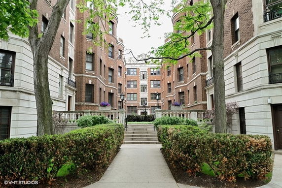 Front view of multiple connected brick apartment buildings with decorative elements.