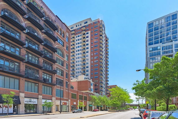 Front view of a tall residential and commercial building with multiple floors and balconies.