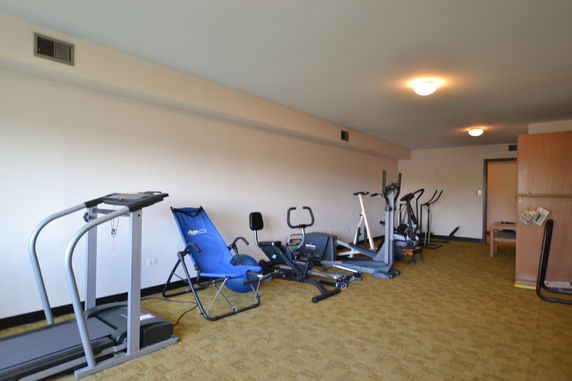 Interior view of a room with exercise equipment, including treadmills and stationary bikes.