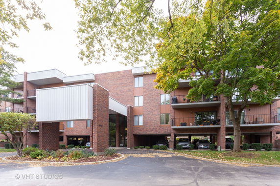 Front view of a multi-story apartment building with brick construction and balconies.