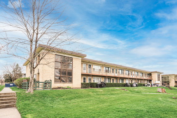 Front view of a two-story building with open balconies and a brick exterior.