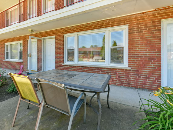 Front view of a brick residential building with two doors and large windows.