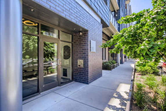Front view of a modern building with glass entrance door and brick exterior.