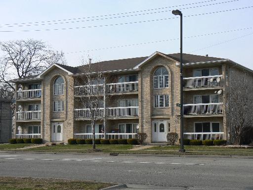 Front view of a three-story apartment building with balconies.