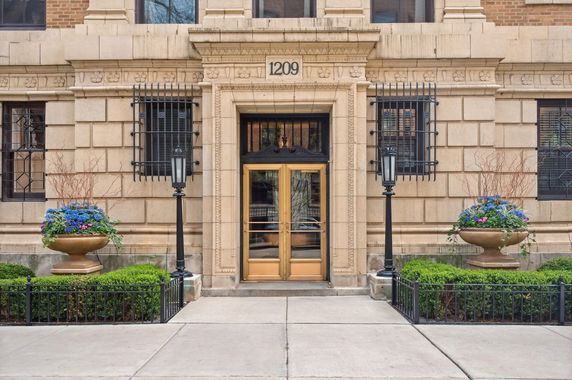Front view of a building entrance with decorative elements and planter arrangements.
