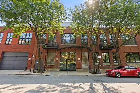 Front view of a brick building with large windows and a garage door.