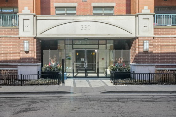 Front view of a building entrance with brick facade and large glass doors.