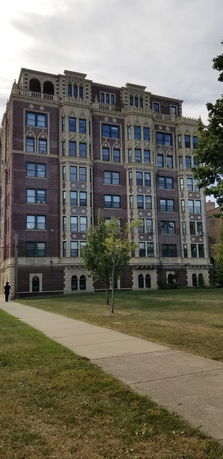 Front view of a multi-story brick building with decorative stonework.