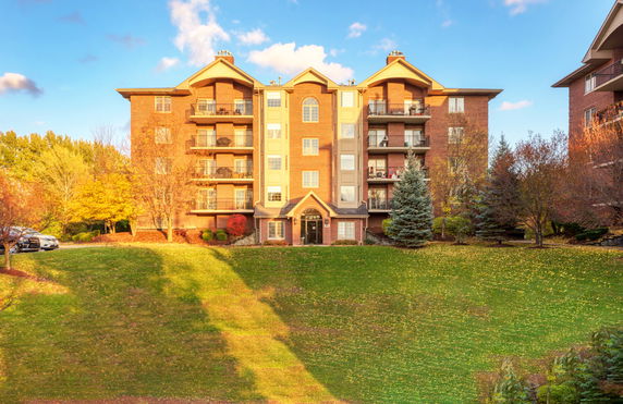 Front view of a multi-story brick apartment building with balconies.