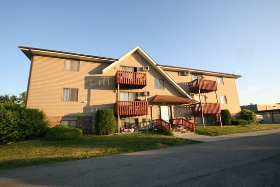 Front view of a multi-story apartment building with balconies.