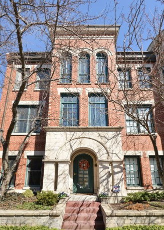 Front view of a multi-story brick building with large windows.