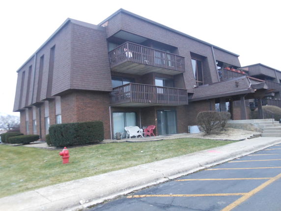 Front view of a multi-story apartment building with balconies.