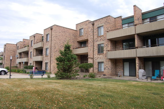Front view of a multi-story brick apartment building with balconies.