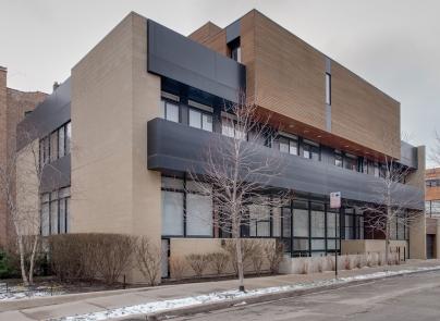 Front view of a modern multi-story building with large windows.