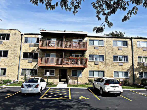 Front view of a three-story apartment building with balconies.