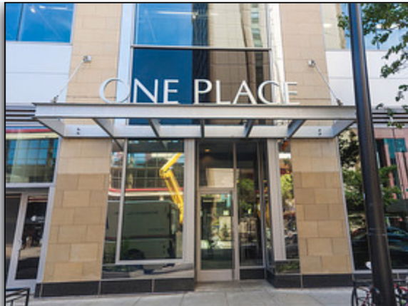 Front view of a building with a glass entrance and 'One Place' signage.