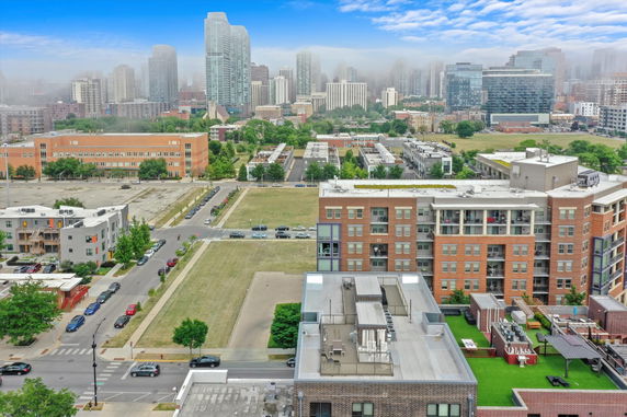 Panoramic view of a cityscape with mid-rise buildings and a park area.