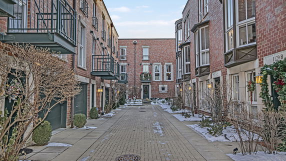 Front view of townhouses with brick exteriors and balconies.