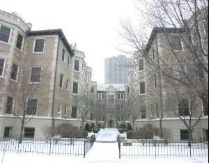 Front view of a multi-story apartment building in winter with snow-covered ground.